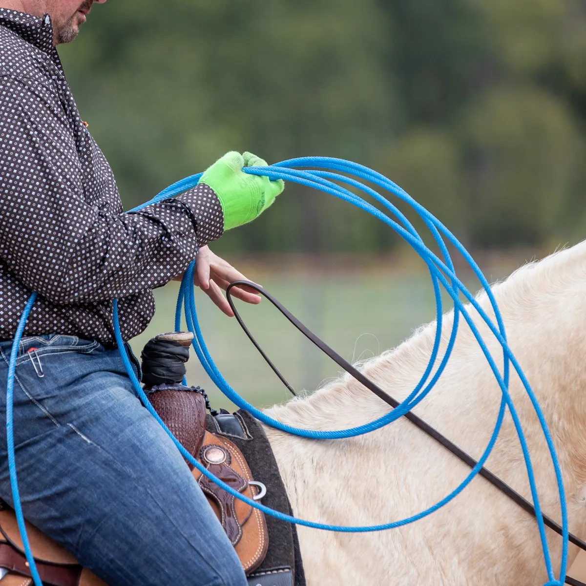 Roper on horseback building a loop with a blue Six Seals 6 rope
